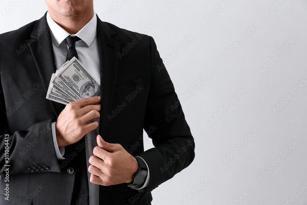 Man with bribe money on light background, closeup. Space for text Man with bribe money on light background, closeup. Space for text