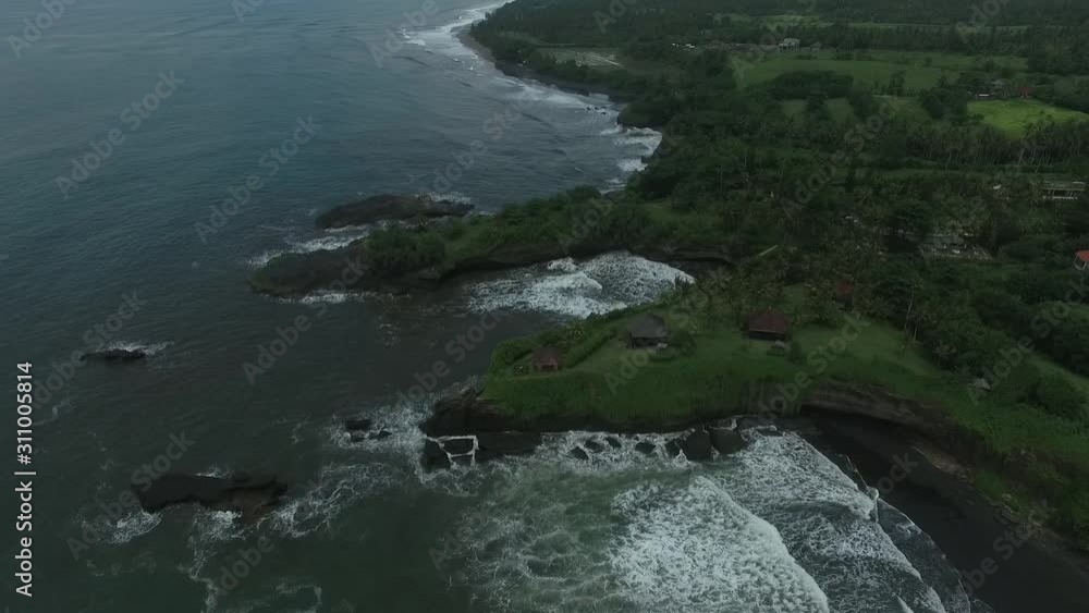 High angle view on the ocean near Bali, rocky shoreline covered in grass High angle view on the ocean near Bali, rocky shoreline covered in grass