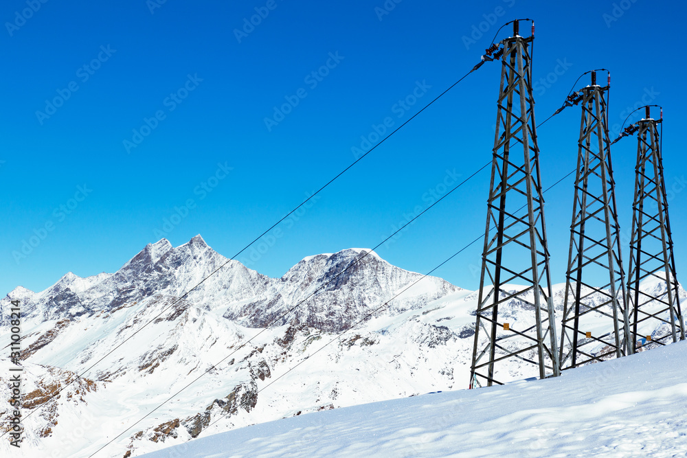 Electric cables on the top of snow-capped mountain.
