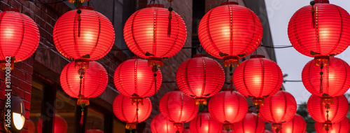 Beautiful round red lantern hanging on old traditional street, concept of Chinese lunar new year festival, close up. The undering word means blessing.