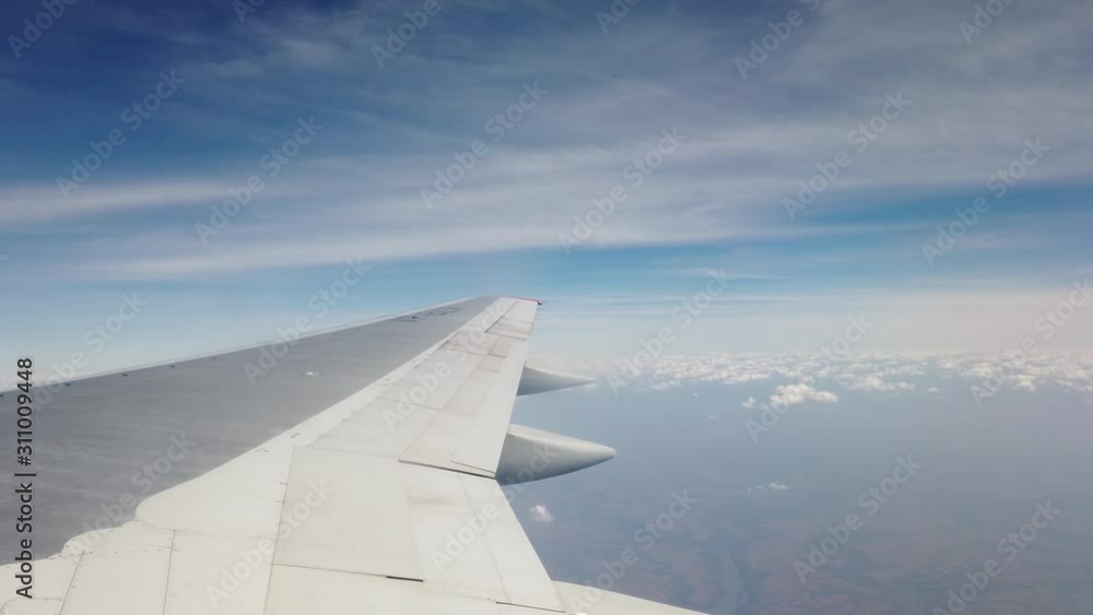 Wing of an airplane flying above the morning clouds. Airplane wing. And blue sky Wing of an airplane flying above the morning clouds. Airplane wing. And blue sky