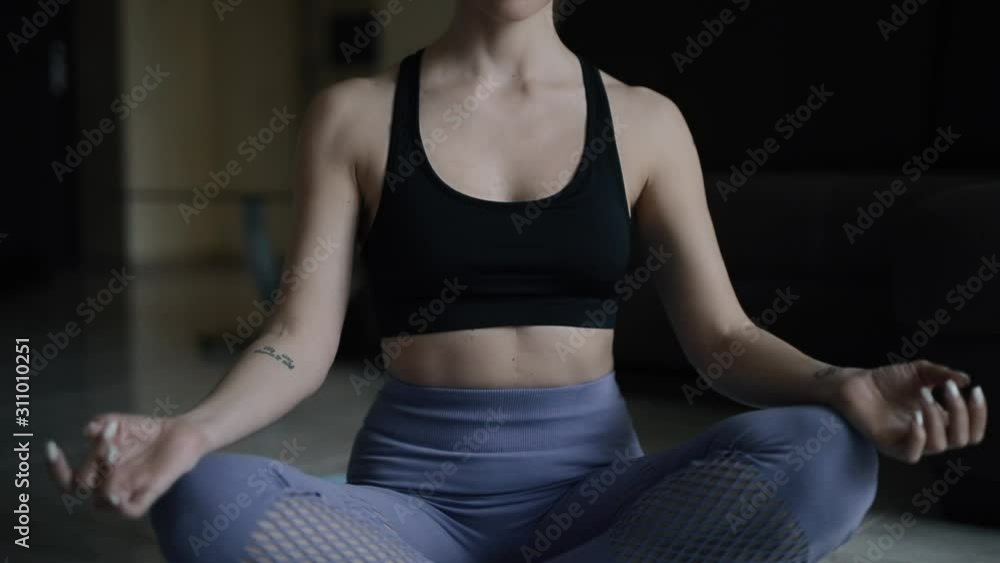 Woman meditating yoga at home sitting in lotus position Woman meditating yoga at home sitting in lotus position