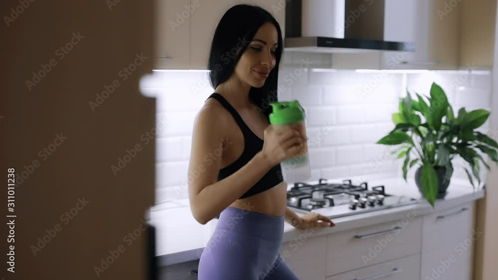 Sportive fitness woman mixing protein in shaker at home Sportive fitness woman mixing protein in shaker at home