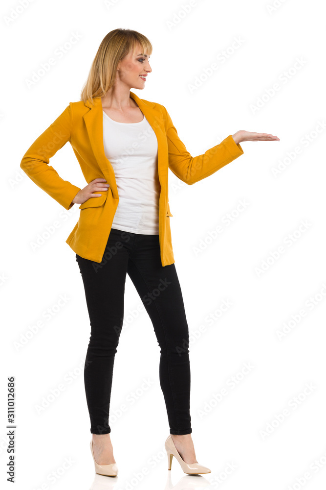Woman In Yellow Jacket Is Standing With Hand Raised And Presenting Woman In Yellow Jacket Is Standing With Hand Raised And Presenting