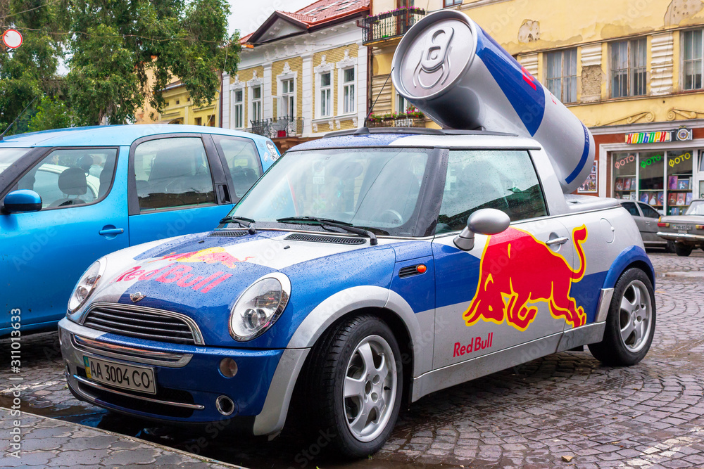 Red Bull mini cooper publicity car with a can of energy drink behind. fancy  car tuning used for promotion. wet advertisement vehicle after the rain  素材庫相片