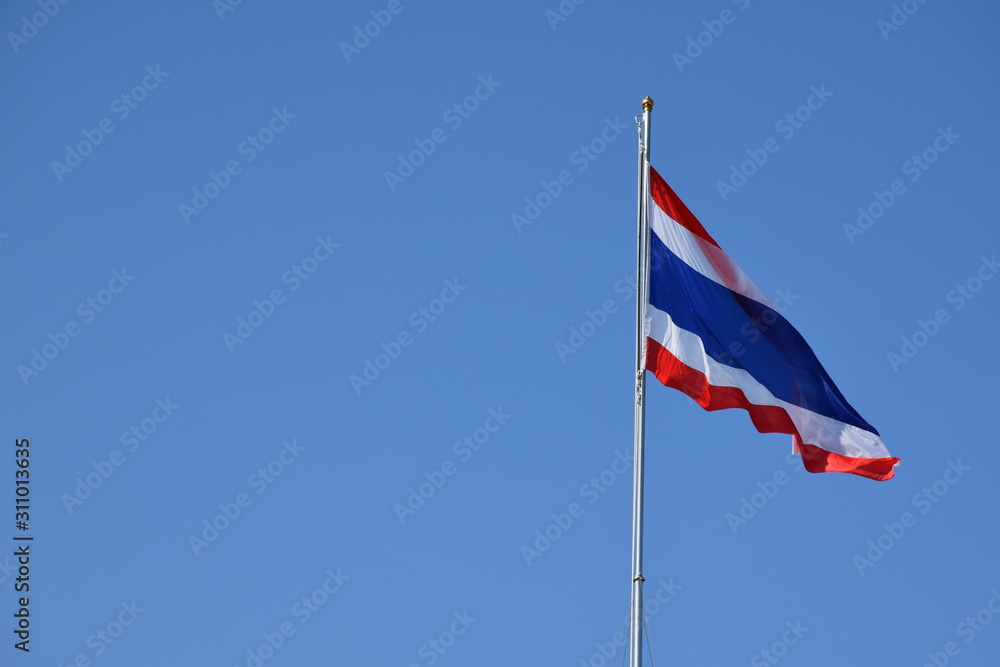 Thailand National Flag on the pole with blue sky.