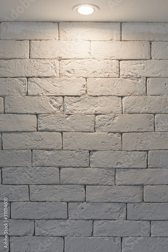 White brick wall lit by a lamp
