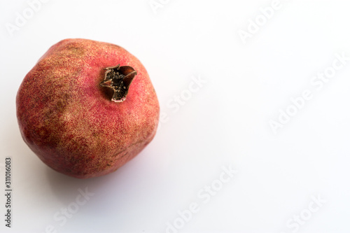 Ripe pomegranate close up on white background