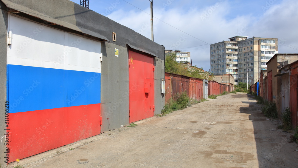Russian - Chinese flags on garage doors in garage colony in the suburbs Russian - Chinese flags on garage doors in garage colony in the suburbs