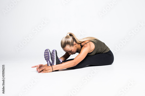 Fit sport woman stretching her leg to warm up isolated over white background