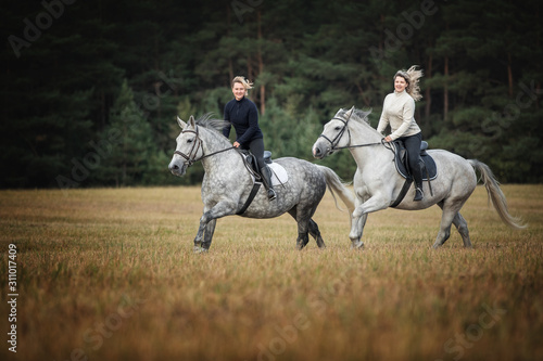 Two women riding horses. © Osetrik