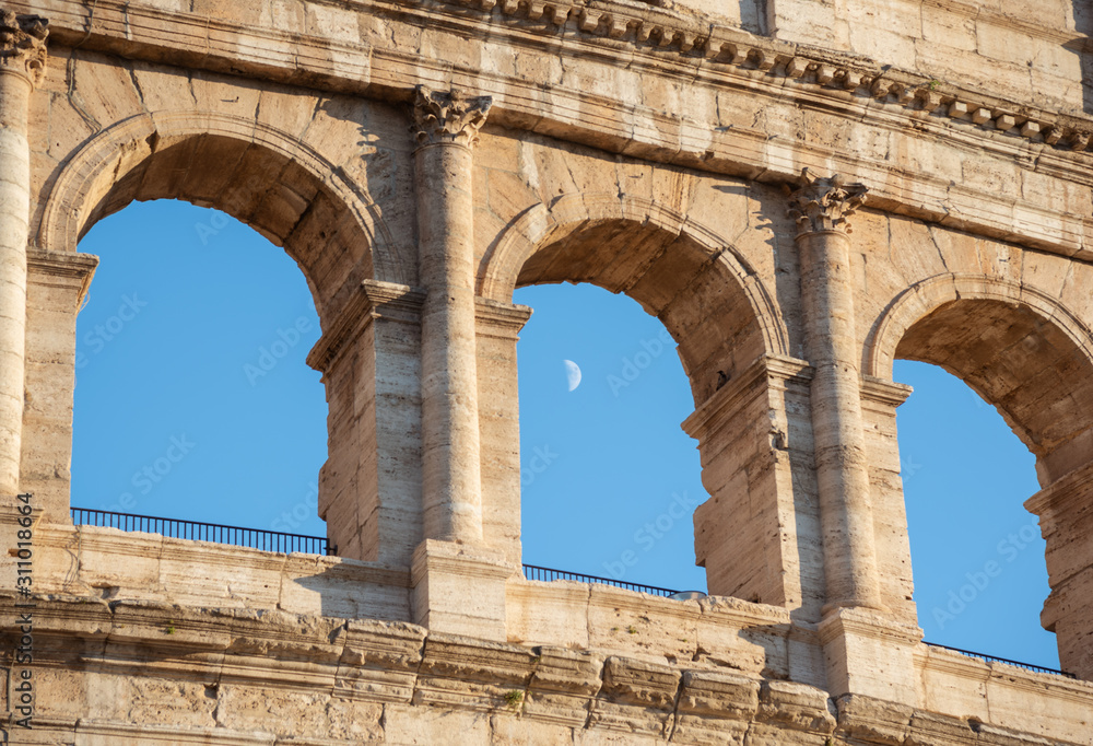 View on Colosseum with moon in arch during sunset