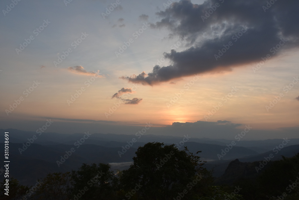 Morning clouds with the sunrise on foggy landscape