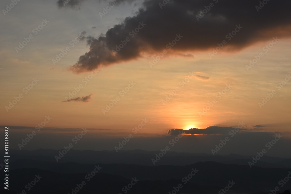 Morning clouds with the sunrise on foggy landscape