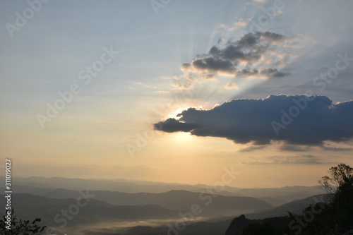 Morning clouds with the sunrise on foggy landscape