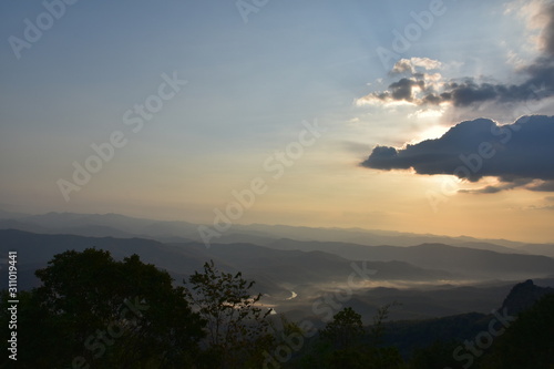 Morning clouds with the sunrise on foggy landscape