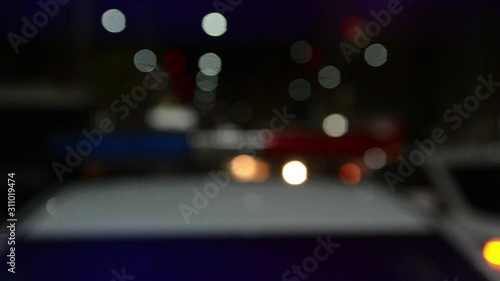 Police emergency lights flashing at a crime scene at night. Flashlights. Car accident and traffic jam. Flashing blue and red lights and signals on patrol car. Emergency car in action. Police raid and 