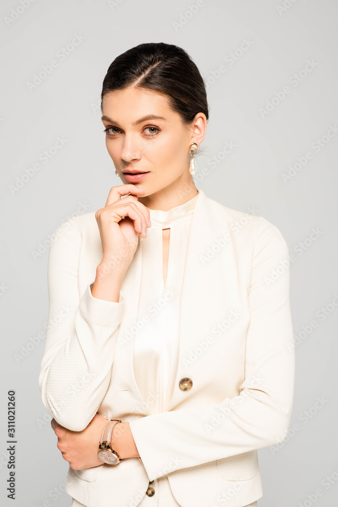 elegant thoughtful businesswoman in white suit, isolated on grey elegant thoughtful businesswoman in white suit, isolated on grey