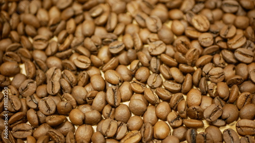 Coffee beans detail roasted cultivated Brazil. Variety Coffea arabica organic bio coffee espresso Italian preparation refreshing, shop store healthy, plant roasting Arabian, light brown background photo