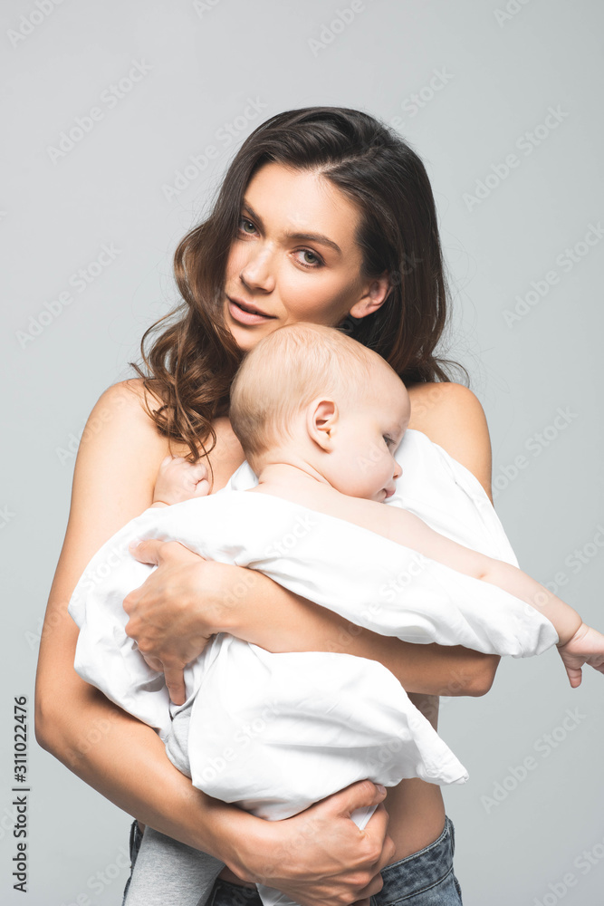 portrait of beautiful naked mom hugging baby, isolated on grey