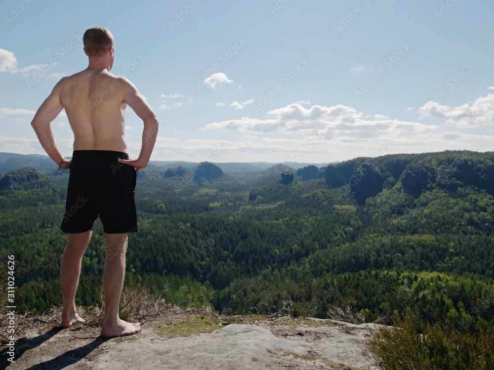 Tall naked man relax for moment on view point. The tourist
