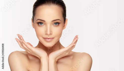Beautiful young woman with clean fresh skin on face . Girl facial  treatment   . Cosmetology , beauty  and spa .