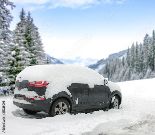 Winter black car cover of snow and winter landscape of forest and mountains. 