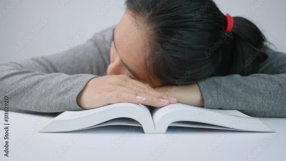 Tired student girl sleeping on the books in room at the Home. Tired student girl sleeping on the books in room at the Home.
