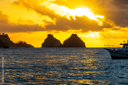 Stunning sunset from a boat in Fernando de Noronha  Brazil. Morro Dois Irm  os  Two Brothers Mountain  can seen at distance.