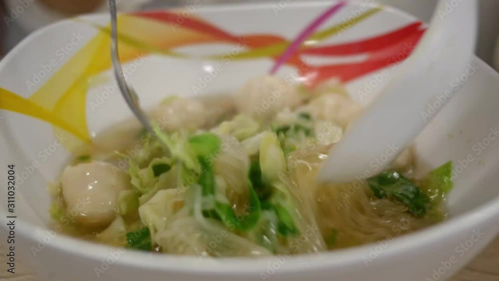 Close up of Hands mixing a noodles meal with a fork and spoon in restaurant. Close up of Hands mixing a noodles meal with a fork and spoon in restaurant.