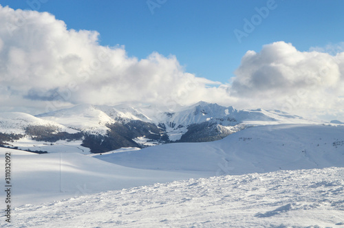 A beautiful viewpoint of the snowy volcanic mountain range during the winter, in Auvergne.