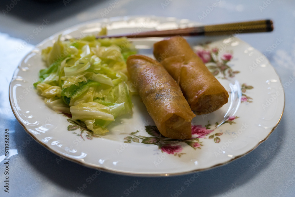 Harumaki on a plate with cabbage salad and chopsticks Harumaki on a plate with cabbage salad and chopsticks