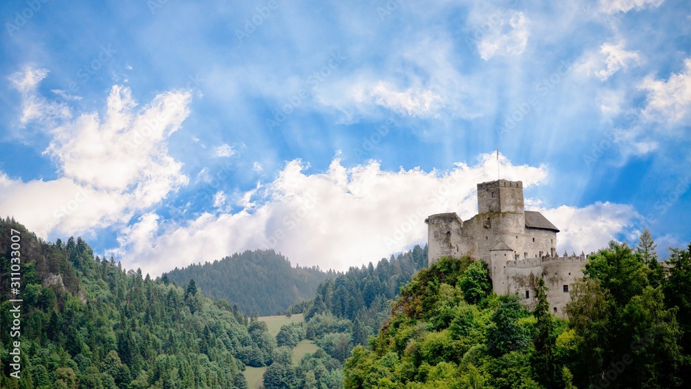 Medieval castle on the green hill and sky with sun rays. Beautiful nature. Niedzica, Poland, 16:9 panoramic format Medieval castle on the green hill and sky with sun rays. Beautiful nature. Niedzica, Poland, 16:9 panoramic format