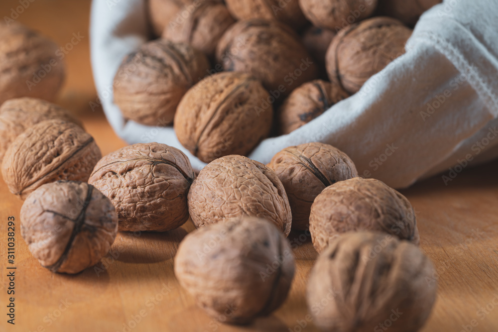 Scattered walnuts on wooden table Scattered walnuts on wooden table