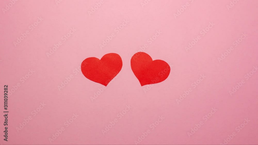 Two red hearts on pink background. Valentines day concept. Flat lay top view stop motion animation with space for text Two red hearts on pink background. Valentines day concept. Flat lay top view stop motion animation with space for text