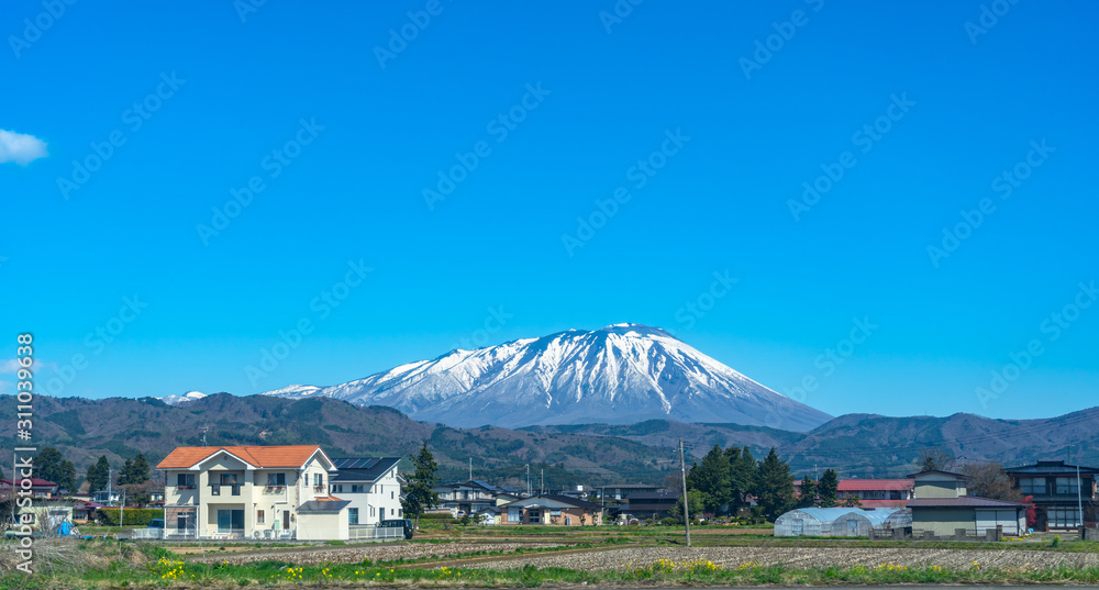Snow capped Mount Iwate with clear blue sky natural background, beauty townscape of Takizawa and Shizukuishi City in springtime season sunny day, Iwate, Tohoku, Japan. Towada-Hachimantai National Park