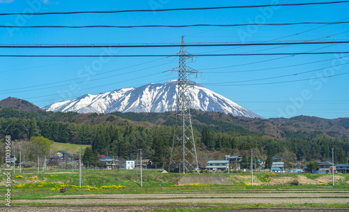 Snow capped Mount Iwate with clear blue sky natural background, beauty townscape of Takizawa and Shizukuishi City in springtime season sunny day, Iwate, Tohoku, Japan. Towada-Hachimantai National Park photo