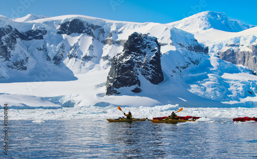 Kajak fahren in der Antarktis mit Eisberge im Hintergrund