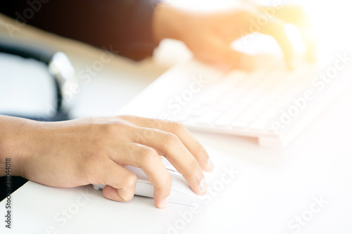 Male Hands Clicking Wireless Computer Mouse Laptop computer on Office Table.