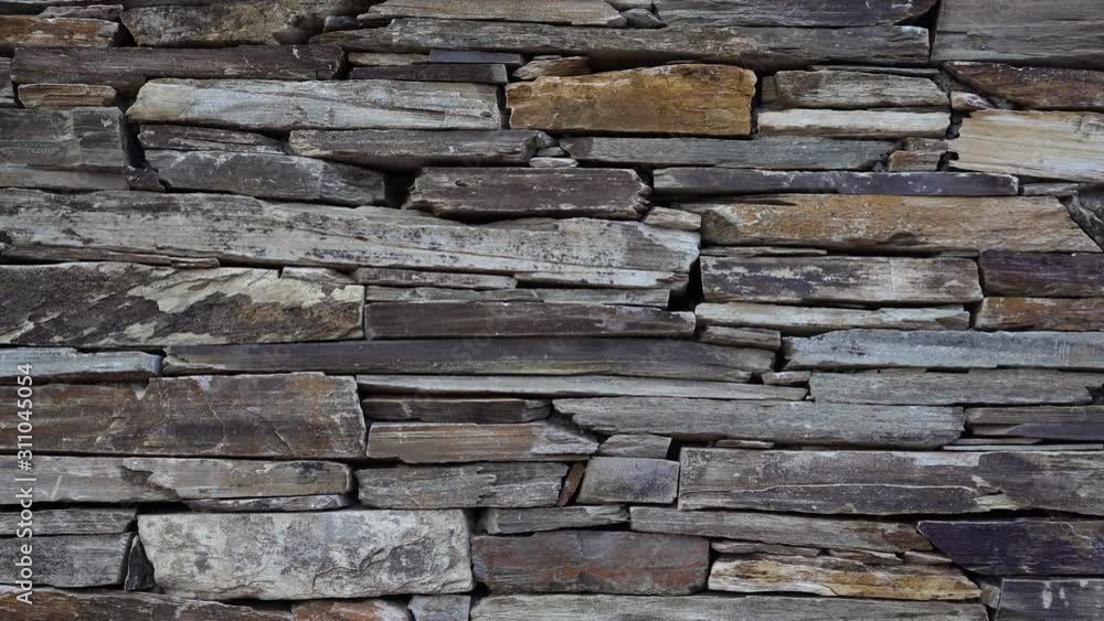 Stone wall made of multi-colored layered natural sandstone Stone wall made of multi-colored layered natural sandstone