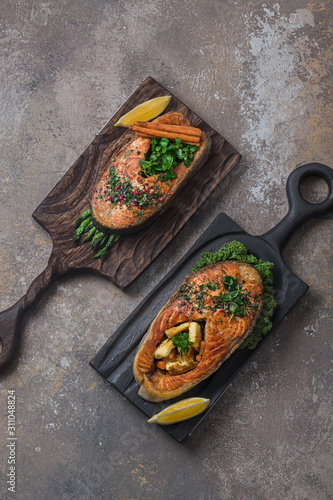 Two salmon steaks with vegetables on wooden boards, copy space