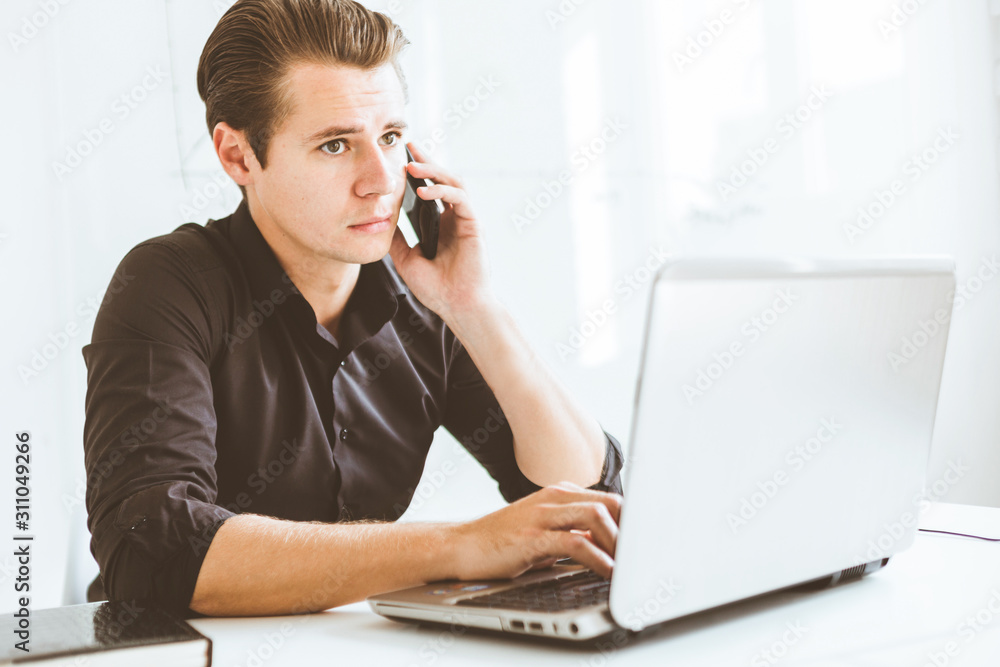 Young businessman working in the office at the laptop Young businessman working in the office at the laptop