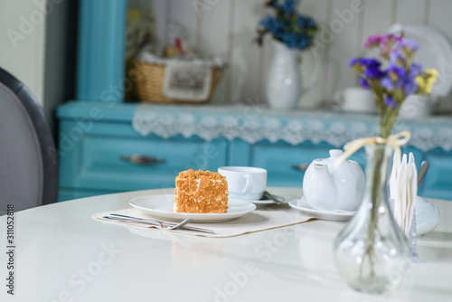 Delicious carrot cake and a cup of black tea on the table in a cozy coffee shop