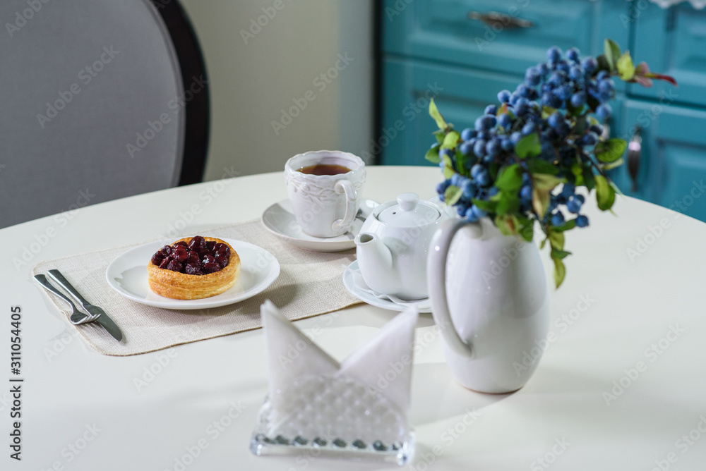 Danish with cherries and black tea on a table in a cozy coffee shop Danish with cherries and black tea on a table in a cozy coffee shop