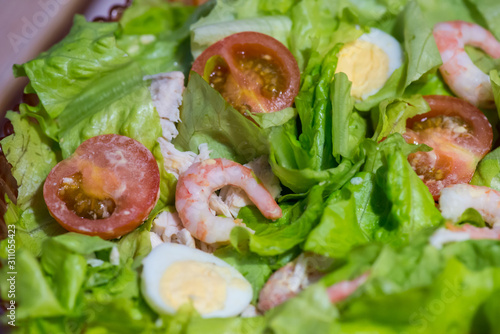Tomatoes, shrimps, eggs and green salad. Closeup