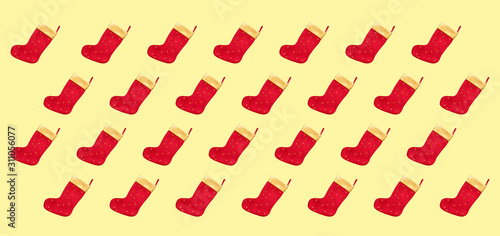 Christmas composition. Pattern made of christmas boots on a yellow background. Christmas, winter, new year concept.