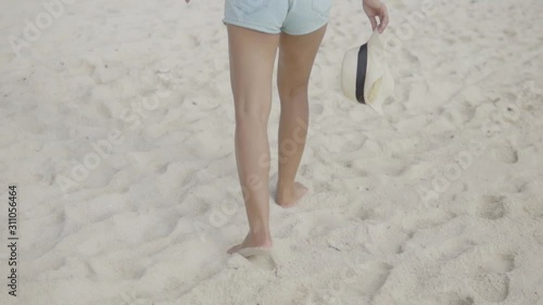 Young woman walking on the beach.