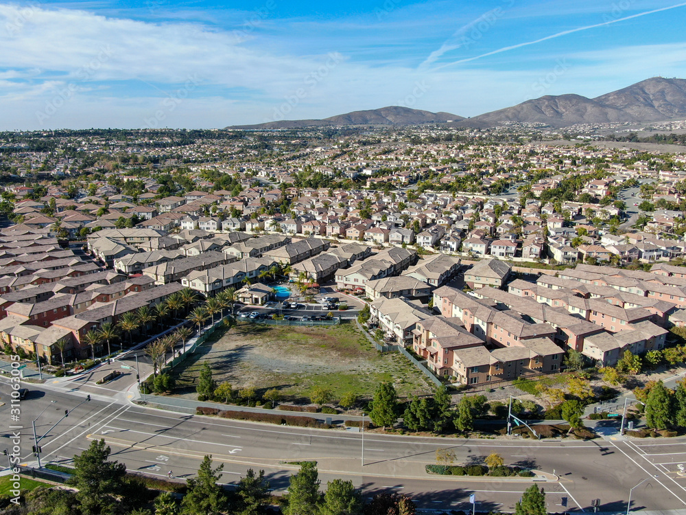 Aerial view of upper middle class neighborhood with identical residential subdivision houses during sunny day in Chula Vista, California, USA.