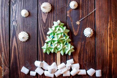 gingerbread sweet Christmas tree, below is sweet snow on the background of a shooting star and snow on a wooden background