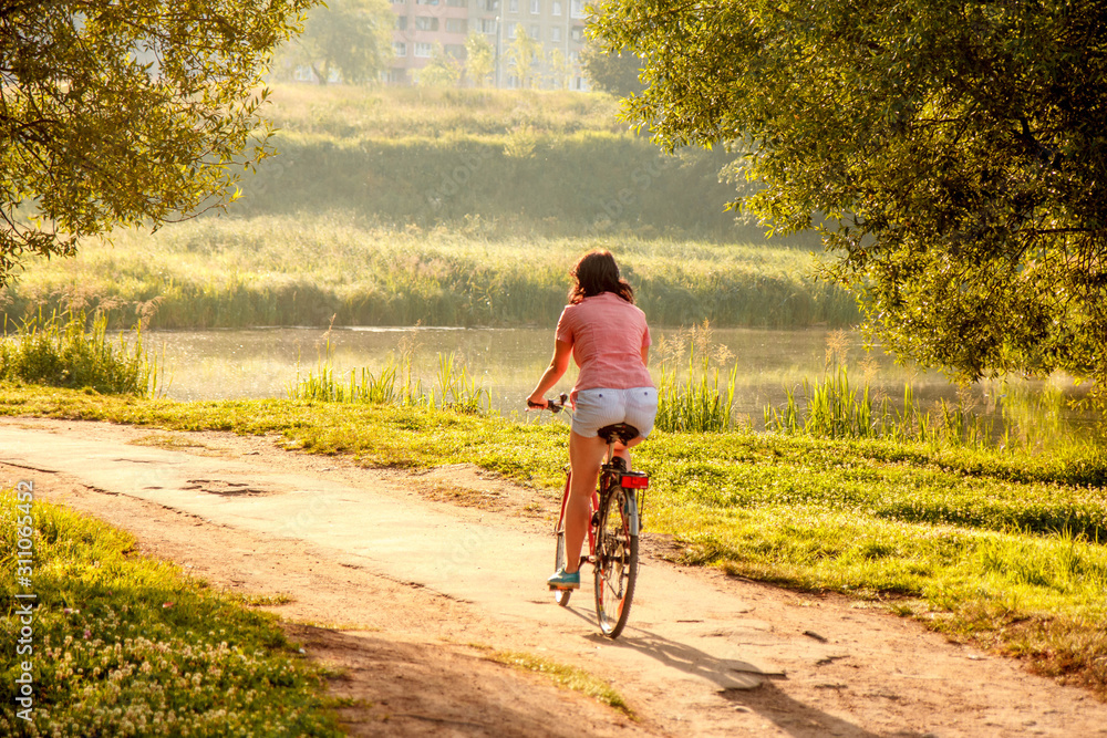 young woman riding a bike in park